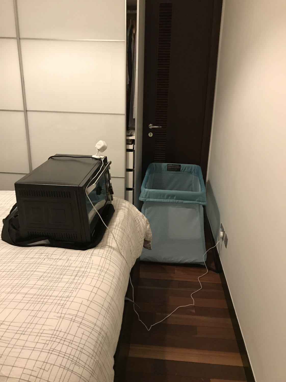   Campbell’s corner in our bedroom while we host. The only space his travel cot fits in between the wardroom and entry to our bathroom. His camera has a magnet, so we improvise the placement with our oven on the bed!  